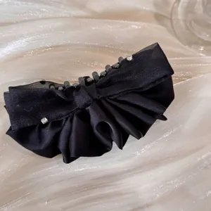 Close-up of elegant black satin bow banana hair clip with sparkling rhinestones