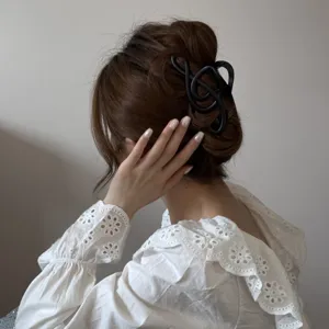 Primer plano de una pinza para el pelo negra con forma de nota musical en un moño de mujer