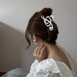 Elegante pinza para el cabello con forma de nota musical blanca en un moño elegante