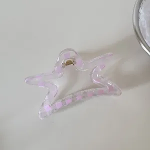 Detalle de una pinza para el cabello en forma de estrella con cuadros rosas y claros.