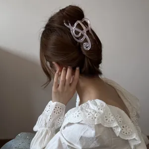 Vista detallada de una pinza para el pelo rosa traslúcida con forma de nota musical