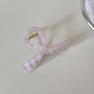 Primer plano de una pinza para el pelo transparente a cuadros rosa para un estilo elegante