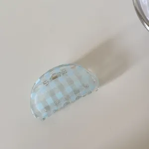Primer plano de pinza para el pelo a cuadros azules translúcida con su textura