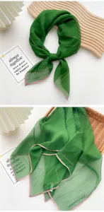 High quality detail of lightweight green square silk scarf with elegant pink trim edging