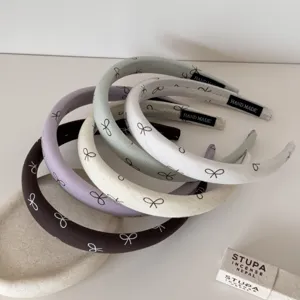 Gros plan de serre-têtes rembourrés français avec motifs de nœuds en couleurs pastel.