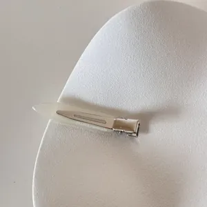 Détail d'une pince à cheveux minimaliste en acétate blanc avec lettrage FRANCE Handmade