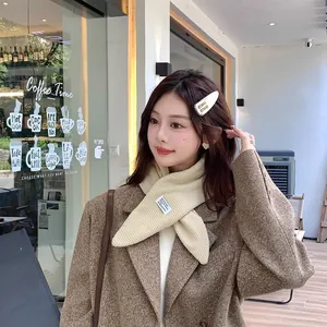 Model wearing a cozy cream-colored quilted puffer scarf with a brown winter coat