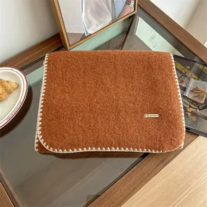 Detailed view of soft orange mohair cashmere blend scarf with elegant white stitched edges