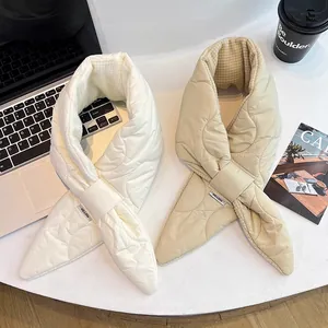 Detailed view of two quilted down cotton puffer scarves in off-white and beige colors