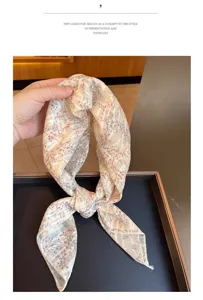 Handheld view of a cotton linen floral scarf with delicate botanical print