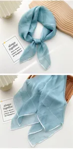 Detailed view of soft light blue silk square scarf featuring delicate white rolled edges