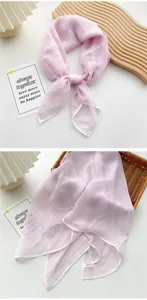 Macro view of a light pink sheer silk square scarf with delicate white hem edges.