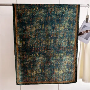 Gedetailleerd beeld van de blauwgroene zijden sjaal met goudkleurig oud schrift