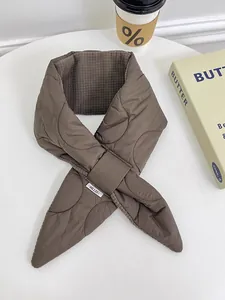 Detailed close-up of brown quilted down-cotton neck warmer with waffle texture lining.