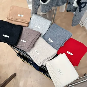 Detailed top view of various colorful 100% wool knitted scarves for winter warmth