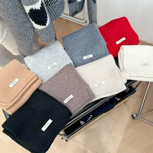 Collection of colorful 100% wool knitted scarves neatly folded to show texture and variety
