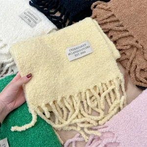 Vista detallada de bufandas de lana bouclé con parches de estudio en varios colores