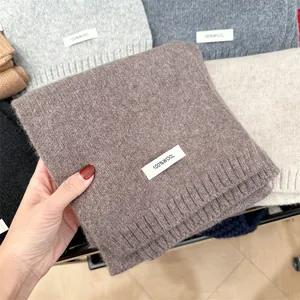 Detailed texture of 100% wool knitted scarf in various neutral winter colors