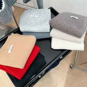 Detailed close-up view of various color 100% wool knitted scarves for winter warmth.