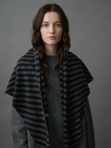 Modell mit einem 100% Wollschal mit schwarz-grauen Streifen für den Winter-Look