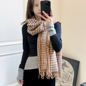 Modella indossa una sciarpa in finto cashmere pied-de-poule marrone con fiori e frange
