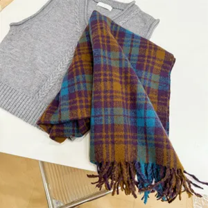 Nahaufnahme eines Vintage-Karoschals mit stilvollen Fransen in Lila und Blaugrün.
