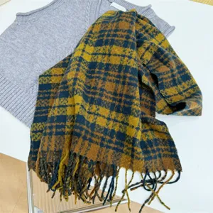 Detailansicht eines vintage gelb und dunkelblau karierten Strickschals mit Fransen