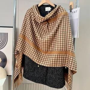 Dettaglio di una sciarpa in finto cashmere con motivo pied-de-poule marrone e frange.