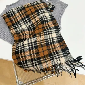 Nahaufnahme eines Vintage-Karoschals mit braunen und schwarzen Mustern und weichen Quasten
