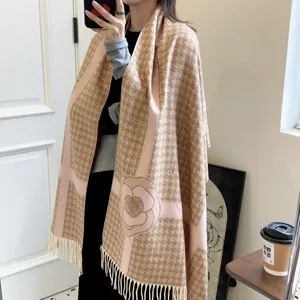 Dettaglio di una morbida sciarpa in finto cashmere con motivo pied de poule e fiori di camelia.