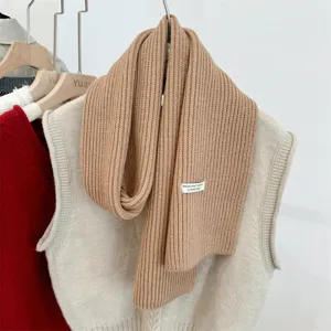 Detailopname van een zachte camelkleurige gebreide sjaal van wolmix met ribbelstructuur