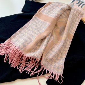 Dettaglio sciarpa rosa pied de poule con motivo a camelia e morbide nappe in finta cashmere
