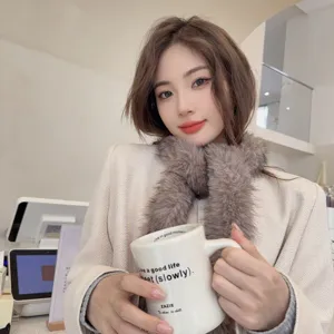 Close-up of a stylish brown faux fur scarf worn by a model in a cozy cafe
