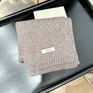 Close-up detail of a soft brown 100% pure wool knitted scarf with authentic label