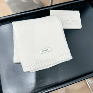 Detail view of a premium white 100% wool knitted scarf with a composition label