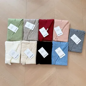 Detail view showing a variety of colorful wool knitted triangle scarves neatly arranged