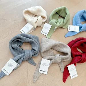 Detailed view of soft wool-blend knitted triangle scarves in six various pastel colors