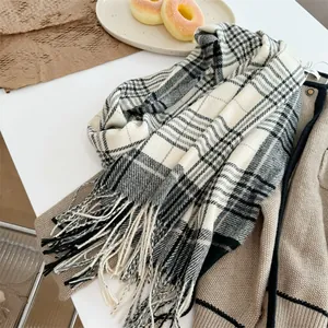 Nahaufnahme eines weichen schwarz-weißen Karoschals mit eleganten Fransenquasten