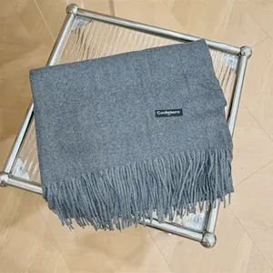 Detalle de una bufanda de cachemira gris suave con elegantes flecos sobre una mesa