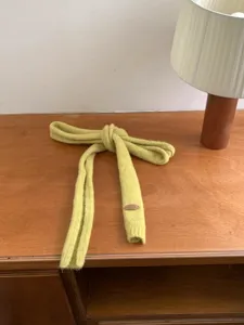 Detalle de una bufanda de punto hecha a mano verde lima con acabado texturizado.