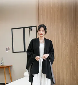 Elegant black knitted shawl cape wrap for women shown on a model in a modern room