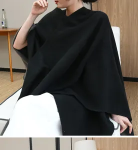 Detailed view of an elegant black shawl poncho wrap for women in a cozy indoor setting