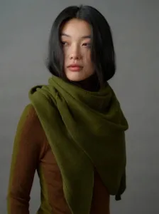 Nahaufnahme eines weichen olivgrünen Strickschals aus 100% Wolle an einem Modell