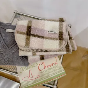Primo piano di una sciarpa in lana bouclé a quadri rosa e marrone