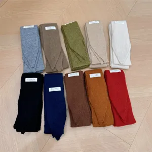 Bufandas de punto estrechas en varios colores con etiquetas sobre madera