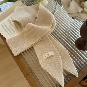 Primer plano detallado de bufanda de punto beige con etiqueta de accesorios Trendy