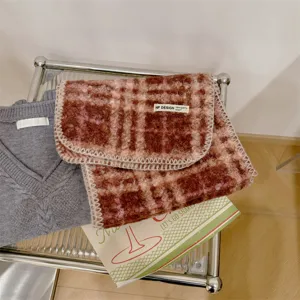 Dettaglio della sciarpa in lana bouclé a quadri con trama strutturata ed etichetta NF Design