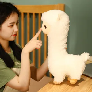 Close-up van een zachte witte pluche alpaca die wordt vastgehouden door een meisje