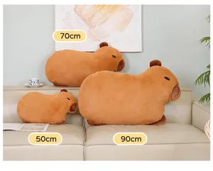 Detailansicht von drei Capybara-Plüschkissen in 50 cm, 70 cm und 90 cm auf einem Sofa