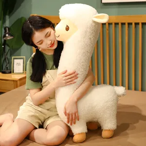 Grote witte zachte alpaca pluche speelgoed kussen vastgehouden door een meisje in slaapkamer